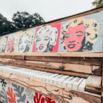 Celebrity Retreat - white and red graffiti on brown wooden fence