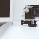 Action Camera - black action camera beside white laptop