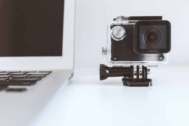 Action Camera - black action camera beside white laptop