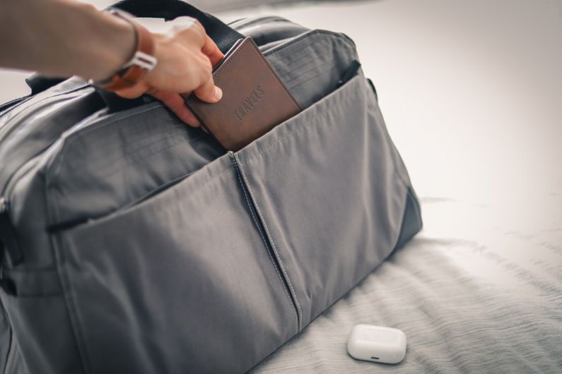 Packing Cubes Review - a person holding a wallet in a bag on a bed