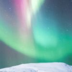 Inspiring Destinations - Colorful polar lights over snowy mountain