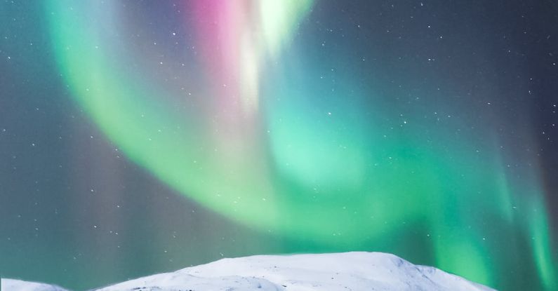 Inspiring Destinations - Colorful polar lights over snowy mountain