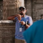 Educational Travel - A Man in Striped Shirt Serving as Tour Guide