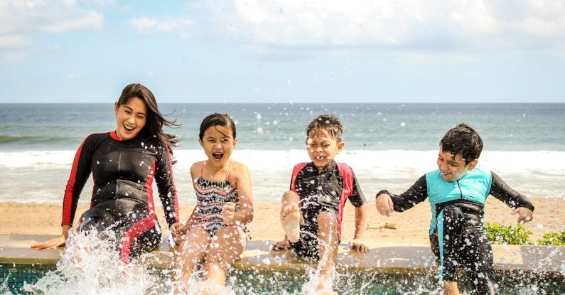 Beach Family - Woman and Three Children Playing Water