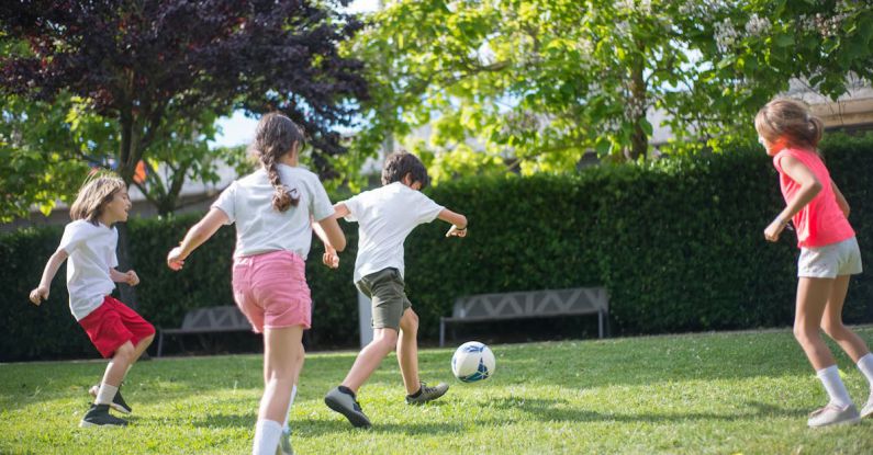 Kid-friendly Activities - Young Kids Playing Football on the Field