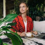 Bali Nomad - Woman in Red and Black Blazer Holding White Ceramic Cup