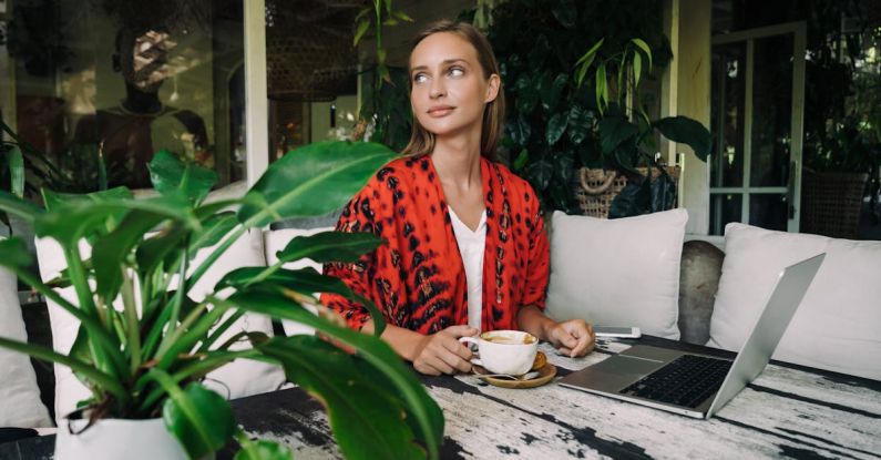 Bali Nomad - Woman in Red and Black Blazer Holding White Ceramic Cup