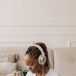 Nomad Packing - A Woman Wearing Her Headphones and Using Her Laptop