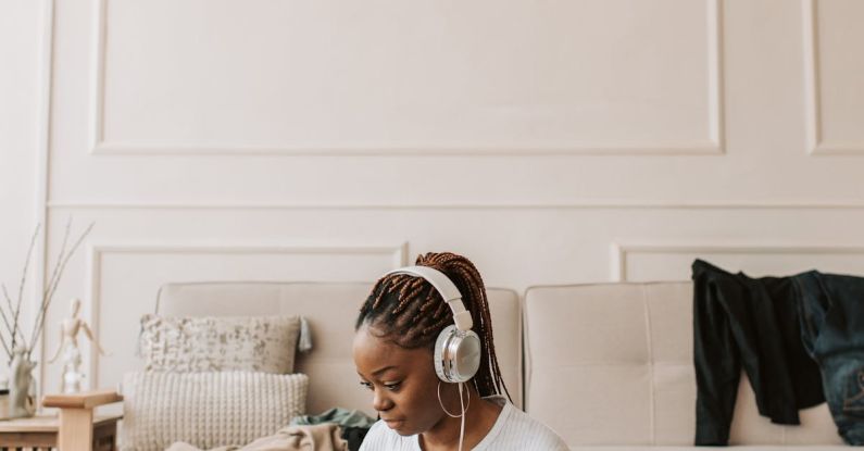 Nomad Packing - A Woman Wearing Her Headphones and Using Her Laptop