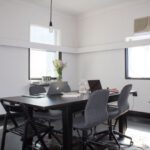 Networking Nomad - rectangular brown wooden table with six chairs and silver MacBook on top