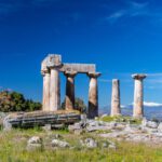 Ancient Ruins - gray concrete pillar on green grass field under blue sky during daytime