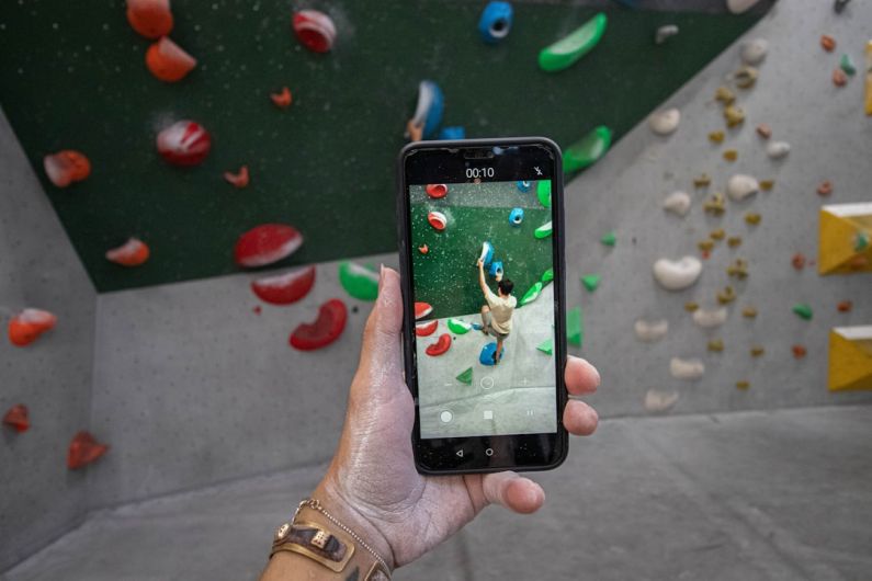 Smartphone Apps - a person taking a picture of a climbing wall