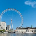 London Eye - white ferris wheel near white concrete building under blue sky during daytime