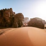 Desert - a person standing on top of a sand dune