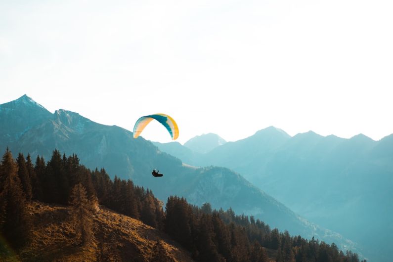 Paraglider - person paragliding near mountain at daytime