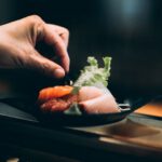 Sushi Plate - left hand picking vegetable on plate