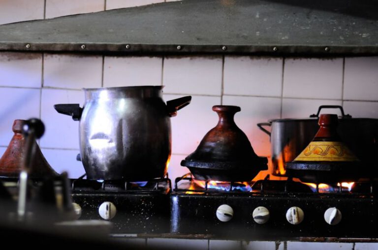 Tagine Pot - stainless steel cooking pot on black stove