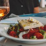 Greek Salad - sliced tomato and cucumber on white ceramic plate