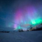 Aurora Borealis - northern lights over snow-capped mountian
