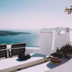 Santorini Luxury - two brown wooden chairs beside the wall